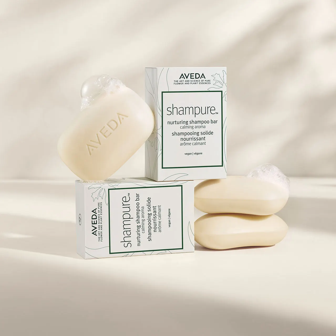 Savons solides Shampure d’Aveda et leurs boîtes, présentés sur un fond ivoire