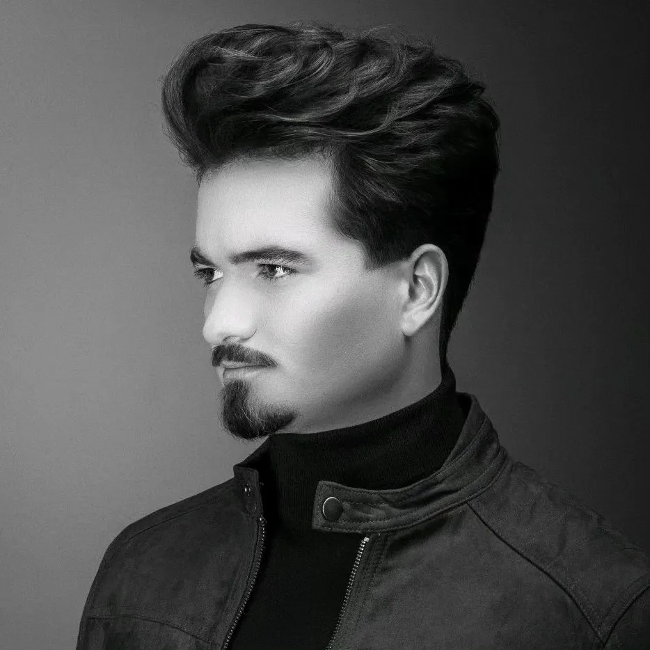 Portrait en noir et blanc d’un homme avec une coupe texturée et une barbe taillée