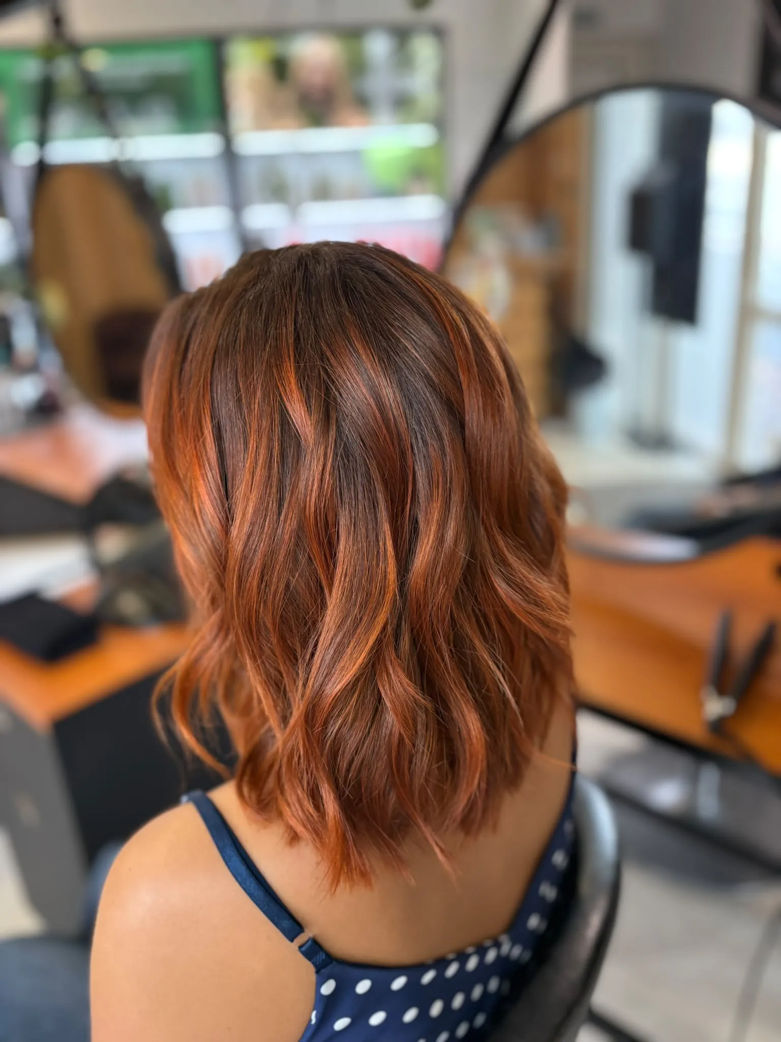 Dos d’une coupe mi-longue roux cuivré, racines foncées et pointes plus lumineuses