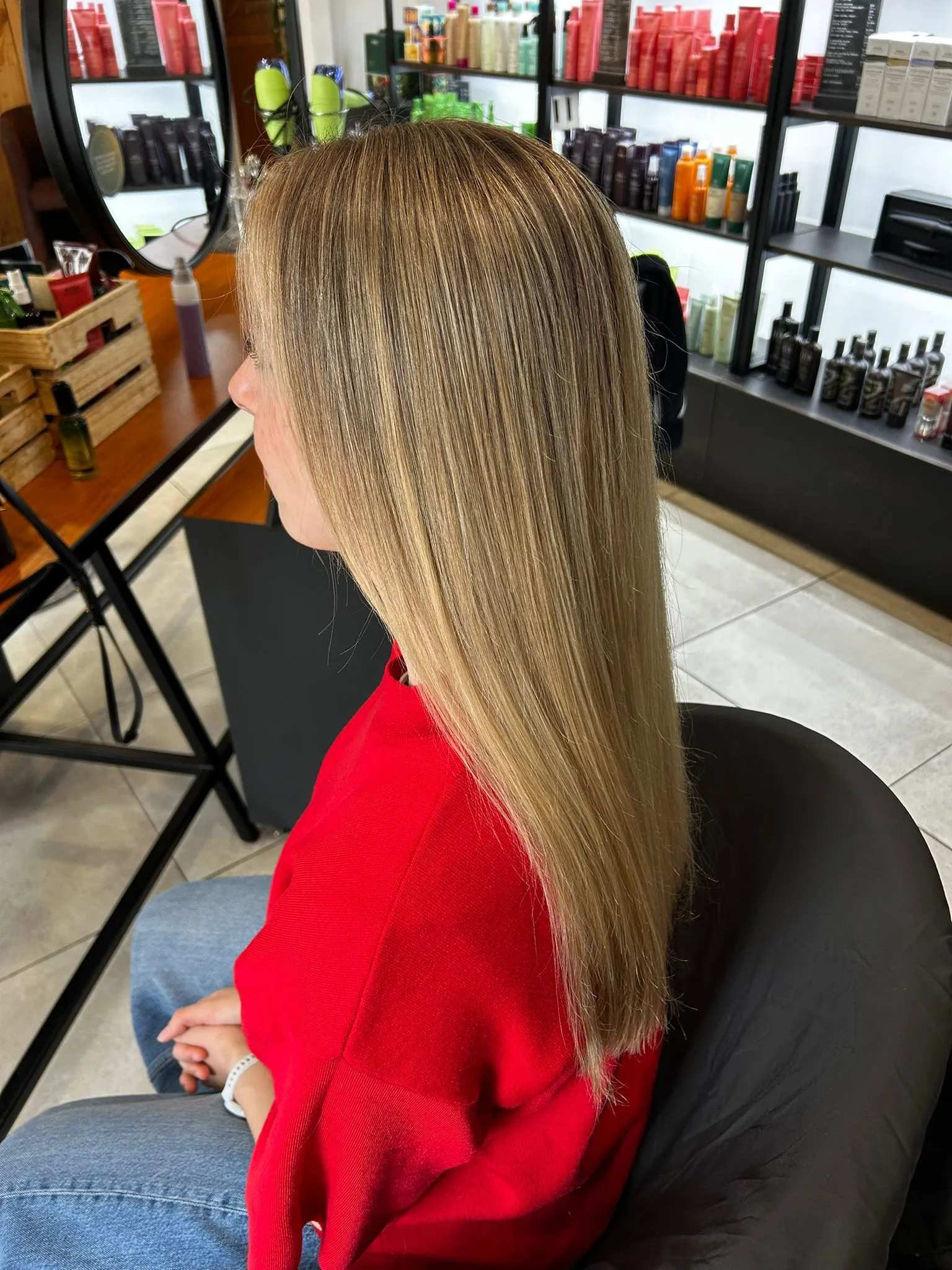 Cheveux blonds longs et lisses vus de profil dans le salon