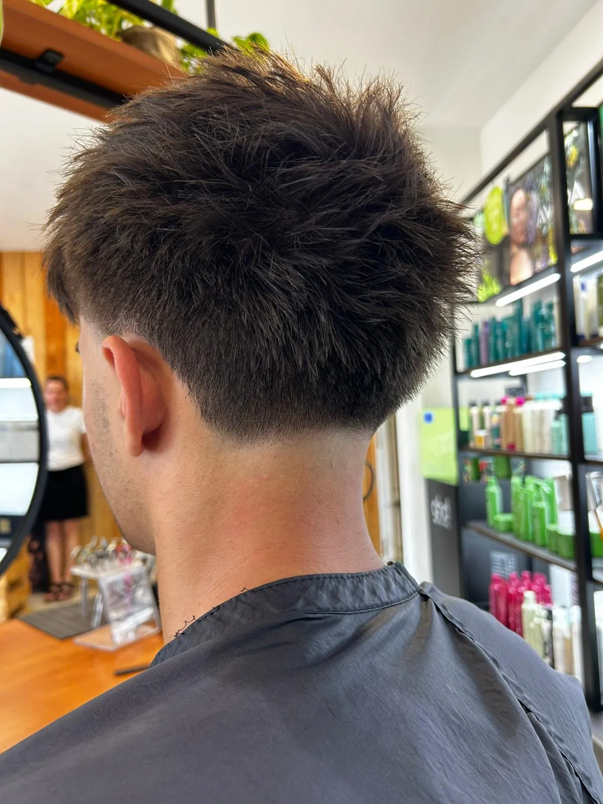 Vue arrière d’une coupe homme dégradée aux cheveux texturés